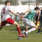 El jugador del Astorga Mario Villar intenta zafarse del marcaje del lateral del Santa Marta Oli.
