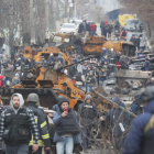 Periodistas caminan por una calle de Bucha entre material bélico ruso destruido. SERGEY DOLZHENKO