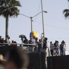 Migrantes en Tijuana, México, miran desde el otro lado del muro durante una visita de la Secretaria de Seguridad, Kirjsten Nielsen.