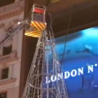 Los bomberos rescatan al hombre del árbol, en la plaza de Callao, en Madrid.