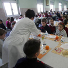 Ninos y niñas comen en un colegio de León.