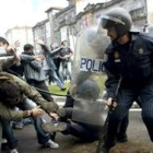 Unos agentes caen al suelo mientras usan sus porras