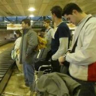 Héctor, Perales, Prendes y Raúl esperan sus maletas en el aeropuerto