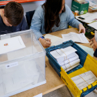 Una empleada de Correos entrega votos por correo en una de las mesas de un colegio electoral. NACHO GALLEGO