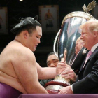 Trump recibe una copa de parte de un luchador de sumo, este domingo en Tokio.