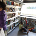 Imagen de una mujer y tres niños en uno de los bibliobuses en la localidad leonesa de Villaquejida.
