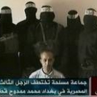 El rehén egipcio está de rodillas y rodeado por seis hombres enmascarados y armados