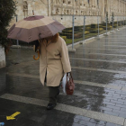 Una mujer sujeta su paraguas al pasar por San Marcos