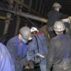 Varios mineros realizan labores de mantenimiento dentro de un pozo