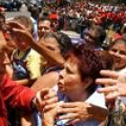 Hugo Chávez saluda a sus seguidores antes de votar en las elecciones