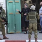 Soldados israelíes interrogan a una mujer palestina.