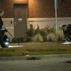 Los investigadores buscan evidencias a las puertas del Departamento de policía de Ferguson.