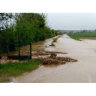 Situación en la que se encontraba ayer el canal de Villares, con la carretera cortada. DL