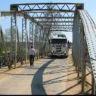 Una góndola para maquinaria pesada recibía ayer las indicaciones oportunas para atravesar el puente