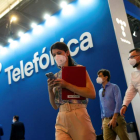 Una joven consulta su teléfono en un expositor de Telefónica. EFE