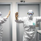 Sanitarios de Valencia reciben indicaciones sobre el modo de colocarse los trajes para tratar el ébola.
