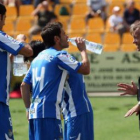 Los jugadores de la Deportiva reciben instrucciones mientras se refrescan en la banda.