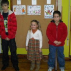 Los tres finalistas del concurso posan delante de sus trabajos, colgados en la pared