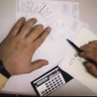 Una persona repasa las facturas con una calculadora