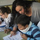 Una madre ayuda a un alumno de primaria en la comunidad de aprendizaje del colegio Joaquim Ruyra de L'Hospitalet de Llobregat.