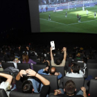 Aficionados siguiendo un partido de fútbol televisado en un cine madrileño.