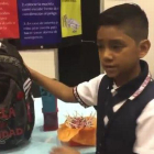 El niño Juan David Hernández presenta la mochila anti-secuestros.