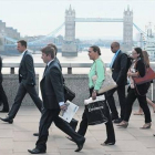 Empleados de la City londinense atraviesan el puente de Londres para dirigirse al trabajo, el pasado agosto.