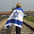 Una mujer camina junto a las vías del tren que lleva a Auschwitz durante la tradicional «Marcha de los vivos».