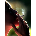 Una mujer fuma un cigarrillo. Imagen de archivo
