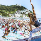 Verómica Blume imparte una clase magistral de yoga en la playa de Ondarreta de San Sebastián.