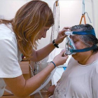 Una mujer con apnea prueba el aparato que usará en casa al dormir.