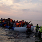 Varios voluntarios ayudan a un grupo de refugiaos a llegar a la costa, en la isla griega de Lesbos, el pasado marzo.