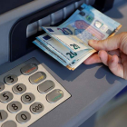 Una persona extrayendo dinero en efectivo de un cajero automático. EMILIO NARANJO