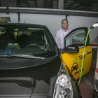 Un taxista carga su vehículo eléctrico en el aparcamiento de su comunidad de vecinos.