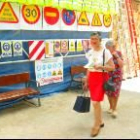 Dos mujeres pasan entre las señales de prohibición, peligro y seguridad de una firma astorgana