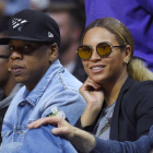 El rapero Jay Z (izq) y su esposa, la cantante Beyonce, asisten a un partido de la NBA.