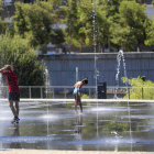 Varias personas se refrescan en la zona de Madrid Río. FERNANDO ALVARADO