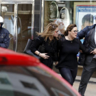 Agentes de la Policía Nacional liberan a uno de los cinco rehenes retenidos hoy, durante poco más de media hora, en el interior de una sucursal de Caixabank, situada en la avenida de la Constitución de Gijón.