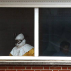 Un sanitario, en una de las habitaciones en las que están aislados los pacientes, en la sexta planta del Hospital Carlos III, el jueves.