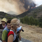 Vecinas de Santa Eulalia desalojadas de sus viviendas contemplan el avance de las llamas.