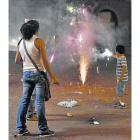 Un niño cerca de una fuente pirotécnica durante las fiestas de Sant Joan.