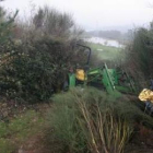 El tractor y el operario quedaron encajados en esta zona de arbustos del campo de golf.