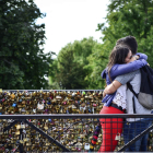 Una pareja se abraza tras colocar un candado en un puente en París. SANDRA JABALERA