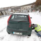 Un conductor pone las cadenas para circular por la A-6, ayer en Vega de Valcarce.