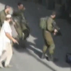 Un colono, con un pistola, tras abatir a un palestino en Hebrón.