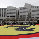Seguidores de Schumacher despliegan una bandera gigante de Ferrari frente al hospital de Grenoble, este viernes.