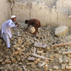 Dos niños afganos mueven los escombros de su vivienda, en el distrito de Nangarhar.