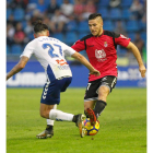 Emi Buendía disputa la posesión del esférico con el jugador chicharrero Luis Pérez durante el partido disputado ayer en Tenerife. JUAN GARCÍA