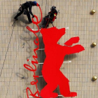 Unos operarios fijan el logo de la Berlinale en el cine Zoo Plast, una de las sedes del festival de Berlín, este miécoles.