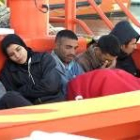 Un grupo de inmigrantes descansan en el barco de salvamento